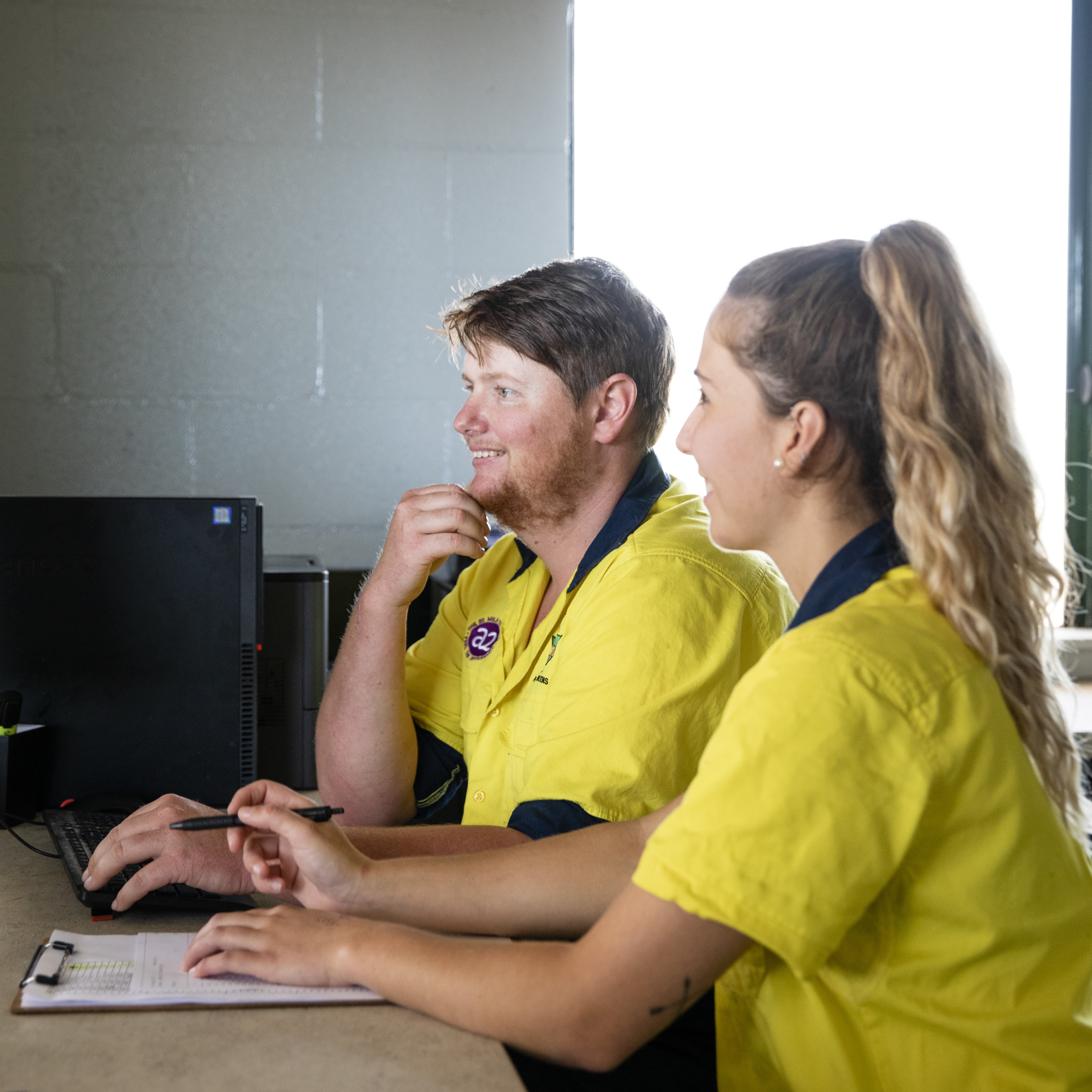Young farmers working on a computer in a dairy office.